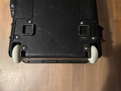 A case lying on it's front, showing the back with two newly replaced wheels