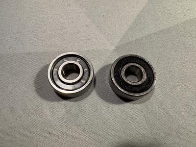 Two replacement bearings. The one on the left shows it's roller carrier, the one on the right it's seal